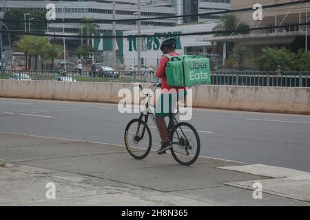 salvador, bahia, brasilien - 30. november 2021: Der Mann mit der Lebensmittelzustellung wird auf einer Straße in der Stadt Salvador mit dem Fahrrad unterwegs gesehen. Stockfoto