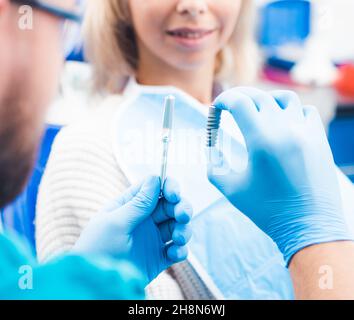 Zahnarzt mit grauem Implantatmodell Stockfoto