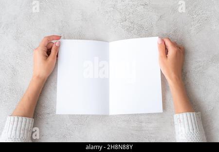 Die Hände des Mädchens halten ein Blatt Papier Stockfoto