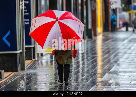 Southport, Lancashire. UK Wetter 01 Dez 2021. Weihnachtsgeschäfte, Einkäufer, die an einem nassen und windigen Tag im Stadtzentrum einkaufen. Der Regen von heute Morgen wird nach Süden ablöschen, aber frische bis mäßige Nordwinde werden anhalten und einen beträchtlichen Kühlfaktor hinzufügen. Credit MediaWorldImages/AlamyLiveNews Stockfoto