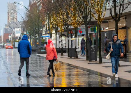 Chapel Street Southport, Lancashire. UK Wetter 01 Dez 2021. Weihnachtsgeschäfte, Einkäufer, die an einem nassen und windigen Tag im Stadtzentrum einkaufen. Der Regen von heute Morgen wird nach Süden ablöschen, aber frische bis mäßige Nordwinde werden anhalten und einen beträchtlichen Kühlfaktor hinzufügen. Credit MediaWorldImages/AlamyLiveNews Stockfoto