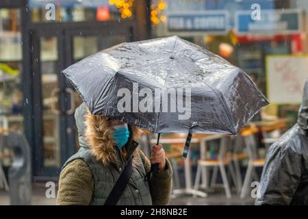 Southport, Lancashire. UK Wetter 01 Dez 2021. Weihnachtsgeschäfte, Einkäufer, die an einem nassen und windigen Tag im Stadtzentrum einkaufen. Der Regen von heute Morgen wird nach Süden ablöschen, aber frische bis mäßige Nordwinde werden anhalten und einen beträchtlichen Kühlfaktor hinzufügen. Credit MediaWorldImages/AlamyLiveNews Stockfoto