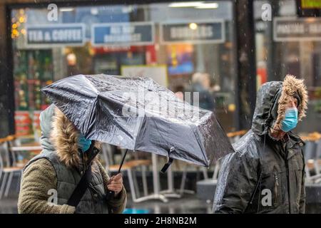 Southport, Lancashire. UK Wetter 01 Dez 2021. Weihnachtsgeschäfte, Einkäufer, die an einem nassen und windigen Tag im Stadtzentrum einkaufen. Der Regen von heute Morgen wird nach Süden ablöschen, aber frische bis mäßige Nordwinde werden anhalten und einen beträchtlichen Kühlfaktor hinzufügen. Credit MediaWorldImages/AlamyLiveNews Stockfoto