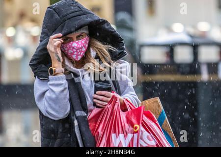 Southport, Lancashire. UK Wetter 01 Dez 2021. Weihnachtsgeschäfte, Einkäufer, die an einem nassen und windigen Tag im Stadtzentrum einkaufen. Der Regen von heute Morgen wird nach Süden ablöschen, aber frische bis mäßige Nordwinde werden anhalten und einen beträchtlichen Kühlfaktor hinzufügen. Credit MediaWorldImages/AlamyLiveNews Stockfoto