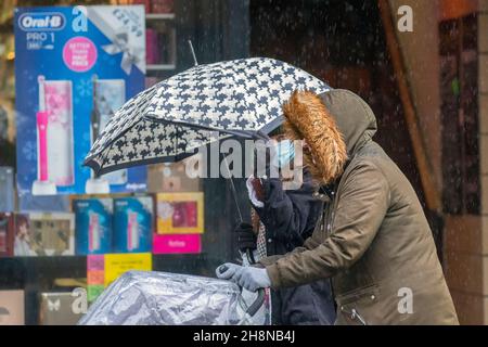 Southport, Lancashire. UK Wetter 01 Dez 2021. Weihnachtsgeschäfte, Einkäufer, die an einem nassen und windigen Tag im Stadtzentrum einkaufen. Der Regen von heute Morgen wird nach Süden ablöschen, aber frische bis mäßige Nordwinde werden anhalten und einen beträchtlichen Kühlfaktor hinzufügen. Credit MediaWorldImages/AlamyLiveNews Stockfoto