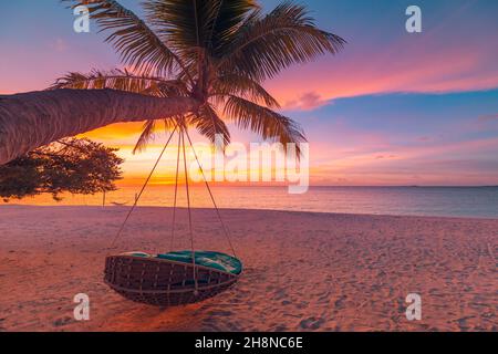 Tropischer Sonnenuntergang Strand Hintergrund als Sommer Küste Landschaft Panorama mit Freizeit Strand Schaukel auf Palmen, weißem Sand und ruhigen Meer Strand Horizont Stockfoto