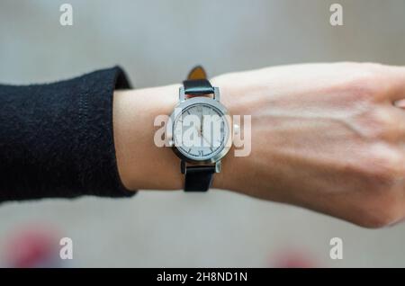 Modische Uhr an der Hand einer Frau. Frau Uhr Zeit auf Armbanduhr Stockfoto