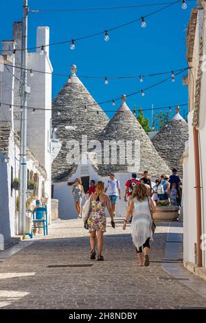 ALBEROBELLO, ITALIEN, 19. AUGUST 2021: Touristen in Alberobello, einer Stadt mit typischen Häusern, die in Apulien, Süditalien, als Trulli bezeichnet werden Stockfoto