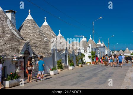 ALBEROBELLO, ITALIEN, 19. AUGUST 2021: Touristen in Alberobello, einer Stadt mit typischen Häusern, die in Apulien, Süditalien, als Trulli bezeichnet werden Stockfoto