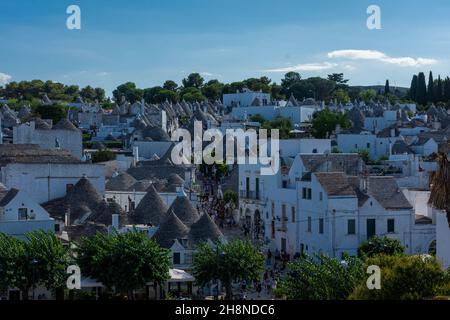 ALBEROBELLO, ITALIEN, 19. AUGUST 2021: Touristen in Alberobello, einer Stadt mit typischen Häusern, die in Apulien, Süditalien, als Trulli bezeichnet werden Stockfoto