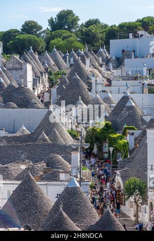 ALBEROBELLO, ITALIEN, 19. AUGUST 2021: Touristen in Alberobello, einer Stadt mit typischen Häusern, die in Apulien, Süditalien, als Trulli bezeichnet werden Stockfoto