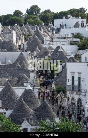 ALBEROBELLO, ITALIEN, 19. AUGUST 2021: Touristen in Alberobello, einer Stadt mit typischen Häusern, die in Apulien, Süditalien, als Trulli bezeichnet werden Stockfoto