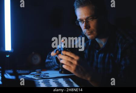 Männlicher Numismatiker fotografiert Sammlung von Münzen zum Verkauf. Stockfoto