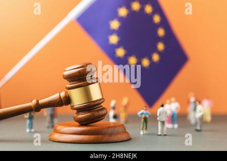 Richter Gavel, EU-Flagge und Kunststoff-Spielzeug Männer auf einem farbigen Hintergrund, das Konzept der Rechtsstreitigkeiten in der europäischen Gesellschaft Stockfoto