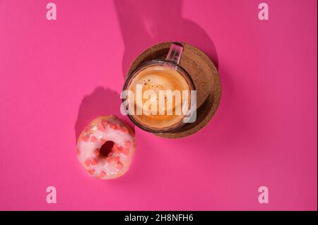 Das Konzept der Liebe für Donuts Espresso Kaffee. Kreative bunte Donuts auf pastellrosa Hintergrund. Minimales Lebensmittelkonzept. Speicherplatz kopieren Stockfoto
