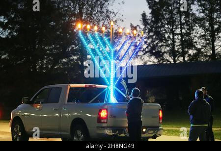 Chesterfield, Usa. 30th. November 2021. Zuschauer sehen sich die riesige Menorah an, die an einem Pickup-Truck befestigt ist, bevor sie am Dienstag, dem 30. November 2021, die jährliche Parade der Chanukah-Auto-Menorah in Chesterfield, Missouri, abhalten. Autos fahren mehrere Meilen in der Parade mit einer beleuchteten Menora, die an ihren Autos befestigt ist, und hören Chanukah-Musik. Foto von Bill Greenblatt/UPI Credit: UPI/Alamy Live News Stockfoto