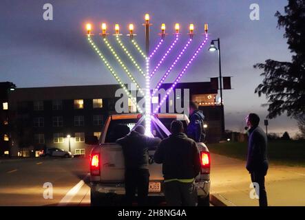 Chesterfield, Usa. 30th. November 2021. Zuschauer sehen sich die riesige Menorah an, die an einem Pickup-Truck befestigt ist, bevor sie am Dienstag, dem 30. November 2021, die jährliche Parade der Chanukah-Auto-Menorah in Chesterfield, Missouri, abhalten. Autos fahren mehrere Meilen in der Parade mit einer beleuchteten Menora, die an ihren Autos befestigt ist, und hören Chanukah-Musik. Foto von Bill Greenblatt/UPI Credit: UPI/Alamy Live News Stockfoto