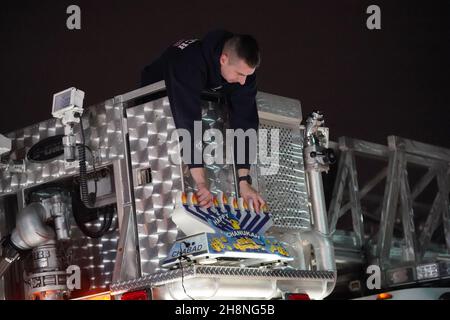 Chesterfield, Usa. 30th. November 2021. Ein Feuerwehrmann aus Monarch stellt eine riesige Menorah auf seinen Feuerwehrwagen, bevor am Dienstag, dem 30. November 2021, die jährliche Chanukah-Menorah-Parade in Chesterfield, Missouri, beginnt. Autos fahren mehrere Meilen in der Parade mit einer beleuchteten Menora, die an ihren Autos befestigt ist, und hören Chanukah-Musik. Foto von Bill Greenblatt/UPI Credit: UPI/Alamy Live News Stockfoto