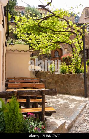 Terrasse eines Restaurants in Tossa de Mar mit Holzbänken und Tischen Stockfoto