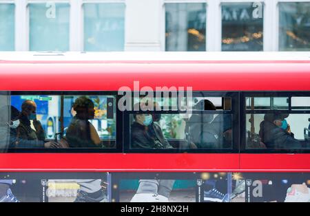 Einige Pendler tragen ihre Maske im öffentlichen Verkehr in London, da Gesichtsbezüge in Geschäften und im öffentlichen Verkehr wieder obligatorisch werden. Stockfoto