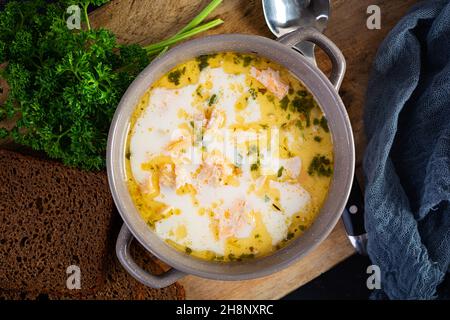 Cremige Lachssuppe mit Kartoffeln, Karotten, Lauch und Brot. Lohikeitto-Suppe, finnische Küche. Draufsicht Stockfoto