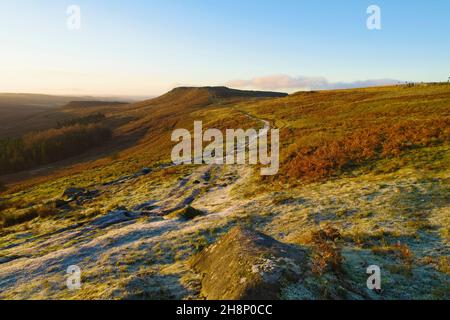 Frostiger Fußweg erstreckt sich über die Hänge des Burbage Valley in Richtung Higger Tor im Derbyshire Peak District. Stockfoto