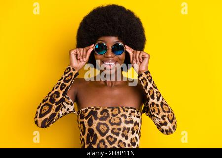 Portrait von attraktiven kühlen fröhlichen Mädchen tragen berührende Spezifikationen isoliert über helle gelbe Farbe Hintergrund Stockfoto
