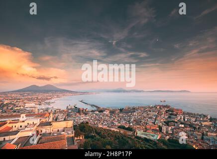 Neapel, Italien. Skyline Stadtbild Stadt im Sonnenuntergang am Abend. Tyrrhenische Meer und Landschaft mit Vulkan Vesuv Stockfoto
