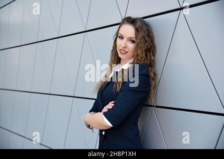 Geschäftsfrau in Polen. Porträt einer jungen Bürodame mit modernem Gebäude als Hintergrund.i Stockfoto