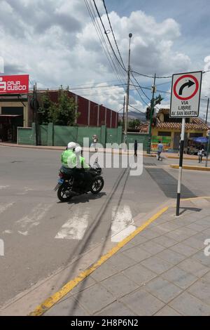 Polizeimotorradfahrer in Cusco Peru zwei Polizisten auf einem Motorradschild Schild Helm beim Aufzug rechts abbiegen grüner Zaun beim Aufzug fangen Stockfoto