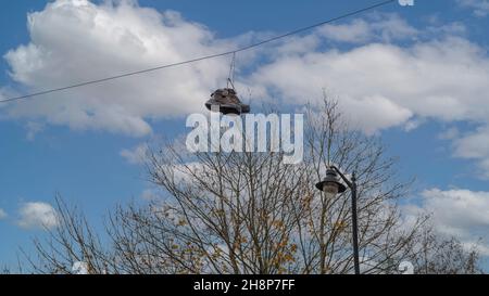 Ein Paar braune Wanderschuhe, die an ihren Schnürsenkeln an einem Draht hängen Stockfoto