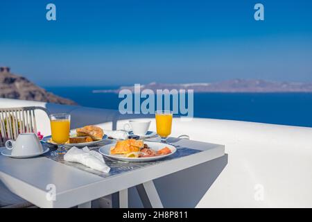 Frühstückstisch romantischer Blick unter dem idyllischen blauen Himmel Meer. Perfekter luxuriöser Frühstückstisch für zwei Personen im Freien. Toller Blick auf die Caldera von Oia Santorini Stockfoto