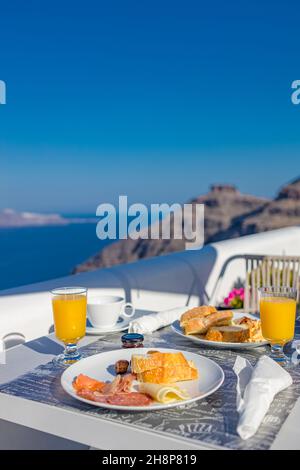 Frühstückstisch romantischer Blick unter dem idyllischen blauen Himmel Meer. Perfekter luxuriöser Frühstückstisch für zwei Personen im Freien. Toller Blick auf die Caldera von Oia Santorini Stockfoto