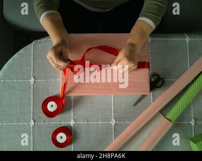 Nahaufnahme der Hand einer Frau, die Geschenke verpackt Stockfoto