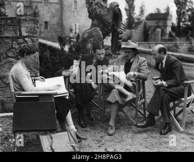 Regisseur RENE CLAIR am Set Candid Überprüfung Drehbuch mit Crew-Mitgliedern während der Dreharbeiten von THE GHOST GOES WEST 1935 Regisseur RENE CLAIR Geschichte Eric Keown Musik Mischa Spoliansky Produzent Alexander Korda London Film Productions / United Artists Stockfoto