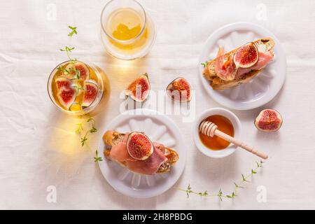 Kleiner Canape-Snack, Crostini mit Schinken, Feigen- und Apfelwein, italienische Antipasti Stockfoto