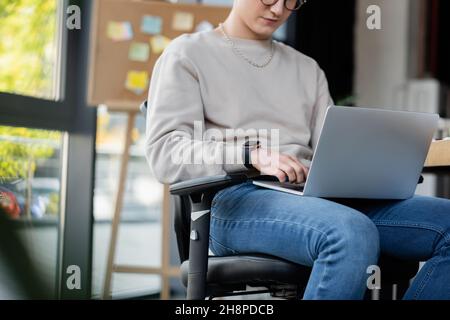 Beschnittene Ansicht eines Geschäftsmannes, der im Büro einen Laptop verwendet, Bild aus dem Stock Stockfoto