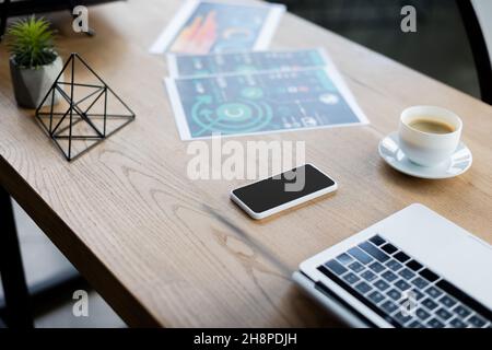 High-Angle-Ansicht von Geräten, Kaffee und Papieren auf dem Tisch im Büro, Stockbild Stockfoto