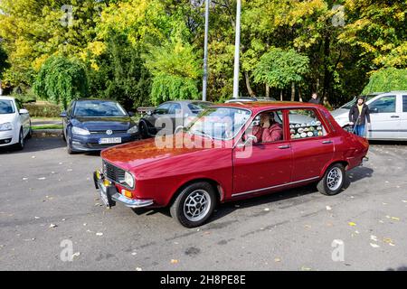 Bukarest, Rumänien, 24. Oktober 2021: Alter, leuchtend roter rumänischer Dacia 1300-Oldtimer im Verkehr im Stadtzentrum an einem sonnigen Herbsttag Stockfoto