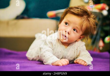 Shallow-Focus-Aufnahme eines Jungen, der in einem Raum auf seinem Bauch liegt Stockfoto