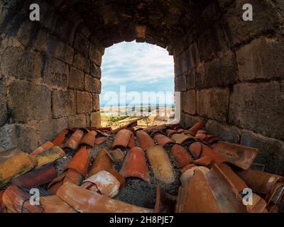 Lehmdachziegel neben einem der Steinfenster der mittelalterlichen Burg von Oropesa in der Provinz Toledo. Stockfoto