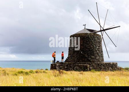 Mutter und Sohn gehen zu den traditionellen Windmühlen Vila do Corvo, Corvo, Azoren, Portugal Stockfoto