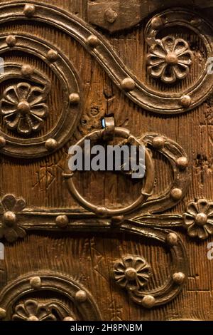 Alte kunstvolle Holztür mit Eisengriff Stockfoto