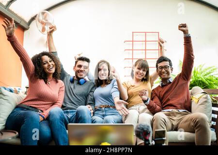 Everiday-Gewinner, junge Gruppe von Studenten, die auf die Kamera schauen und Erfolge feiern, Influencer bei der Arbeit während der Übertragung Stockfoto