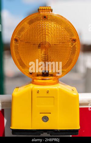 Orangefarbenes Warnblinklicht an einer Baustellenbarriere Stockfoto