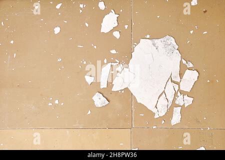 Das Innere ist ein altes Haus, das renoviert werden muss. Der zerbröckelnde weiße Putz von der Wand liegt auf dem Boden, in der Nähe des alten Heizkörpers. Stockfoto