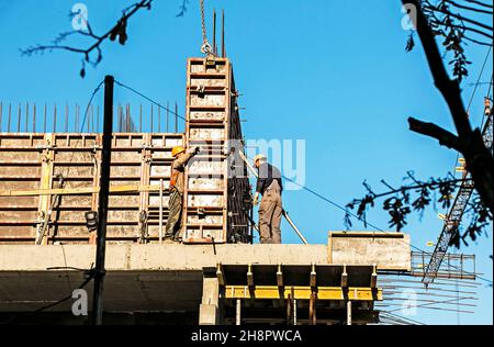 Dnepropetrovsk, Ukraine - 11.30.2021: Die Arbeiter montieren Metallschalungen während des Baus eines Wohngebäudes. Stockfoto