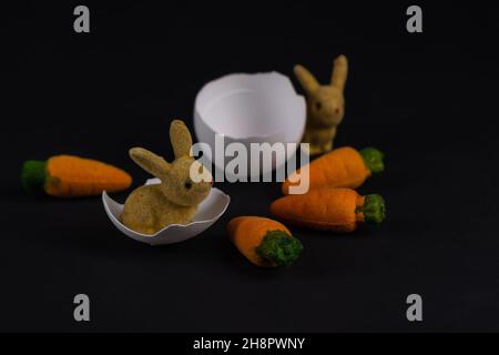 Zwei dekorative Osterhasen mit Eierschalen und vier Karotten Stockfoto