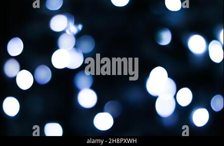 Weihnachtszeit und Urlaubsstimmung Konzept. Verschwommenes blaues Weihnachtsbaumlicht als Bokeh-Hintergrund Stockfoto