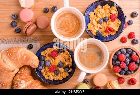 Espresso-Kaffee mit Frühstücksschaum, Cornflakes und Makronen-Kekse für zwei Personen. Leckeres und effektives Frühstück, Nahaufnahme. Speicherplatz kopieren. Oben Stockfoto